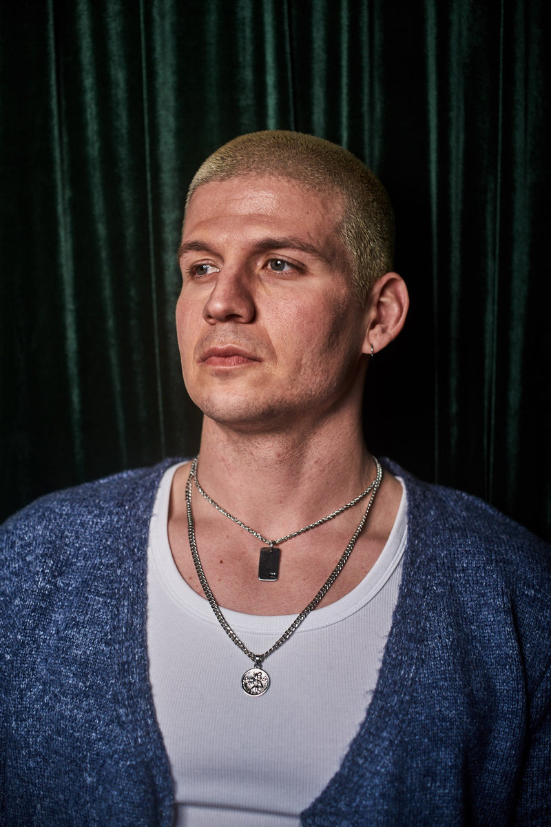 Plain Dog Tag - Man wears layered silver chain necklaces, dog tag and St Christopher pendants.