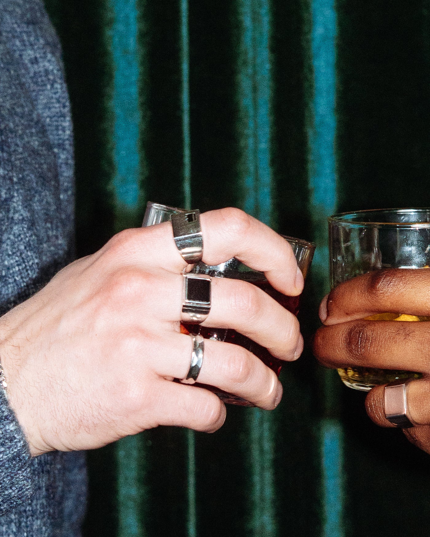Onyx Signet Ring - stacked with Crown Signet Ring, Plain Signet Ring and Hammered Band Ring, two hands toasting with cocktails