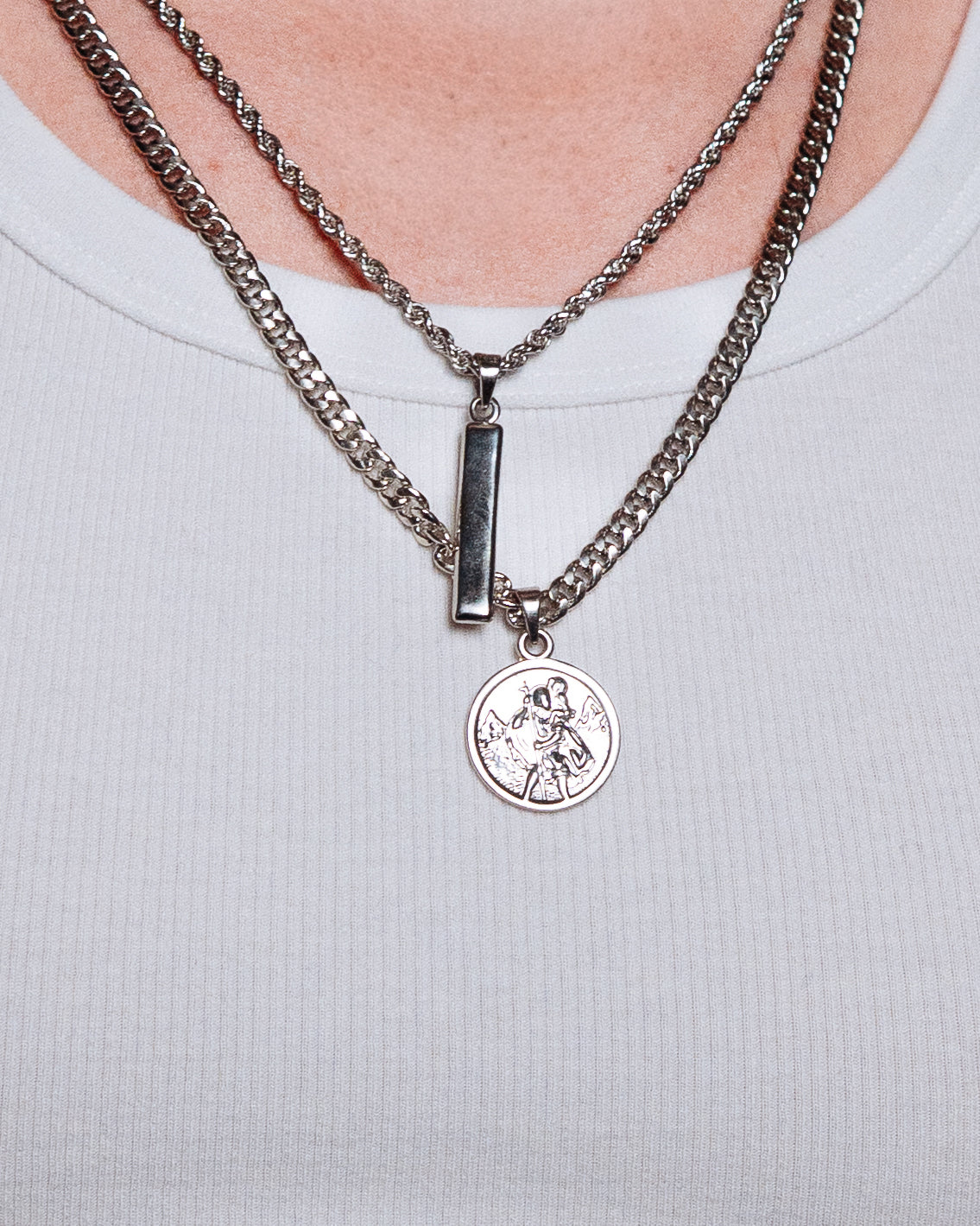 St Christopher Pendant - styled with Totem Pendant, Crown Dog Tag, Cuban Chain 5mm and Rope Chain 3mm, pendants and chains styled together on dark wood surface