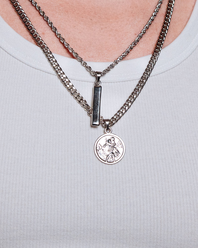 St Christopher Pendant - styled with Totem Pendant, Crown Dog Tag, Cuban Chain 5mm and Rope Chain 3mm, pendants and chains styled together on dark wood surface