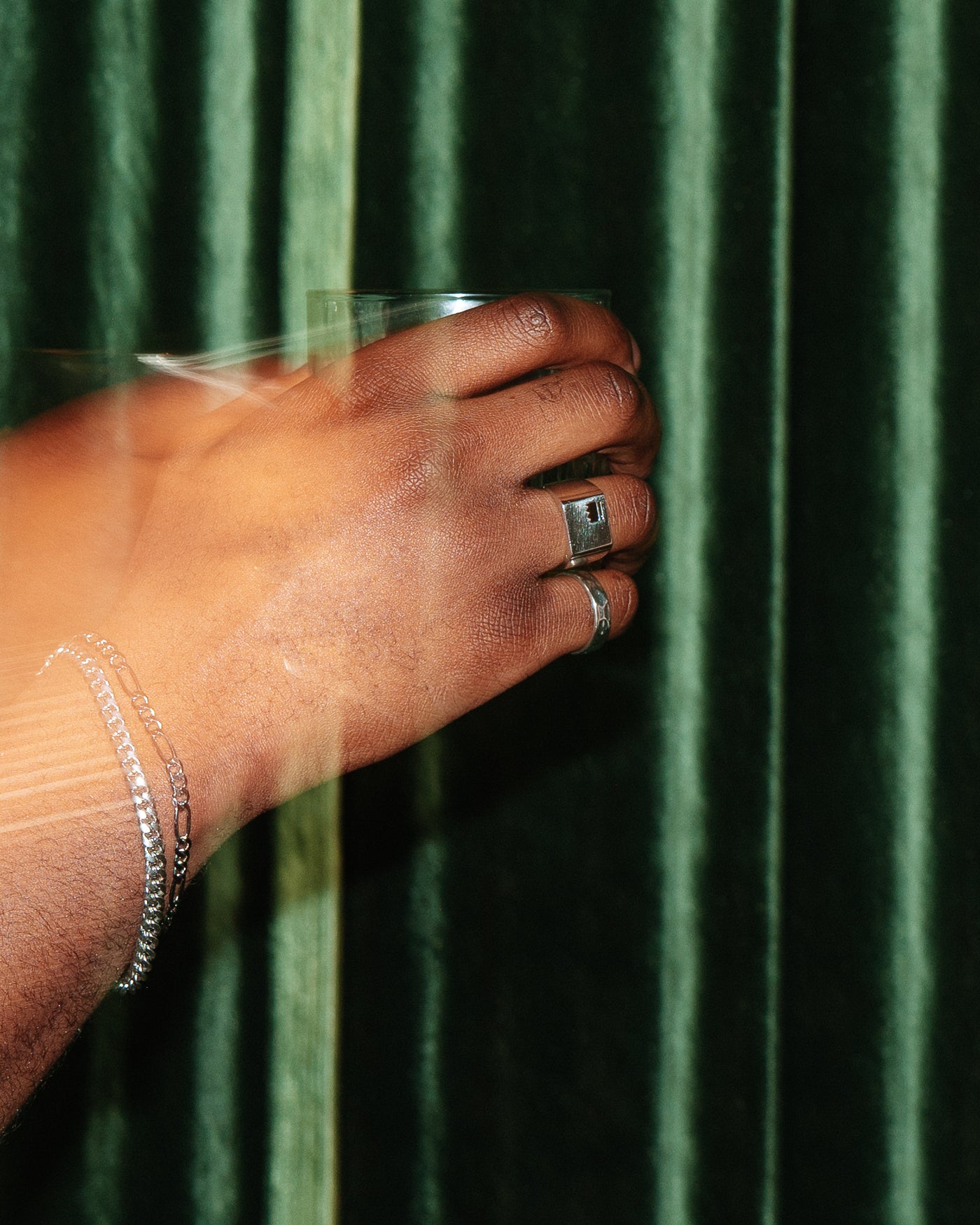 Crown Signet Ring - styled with Hammered Band Ring, hand against green velvet curtain holding cocktail