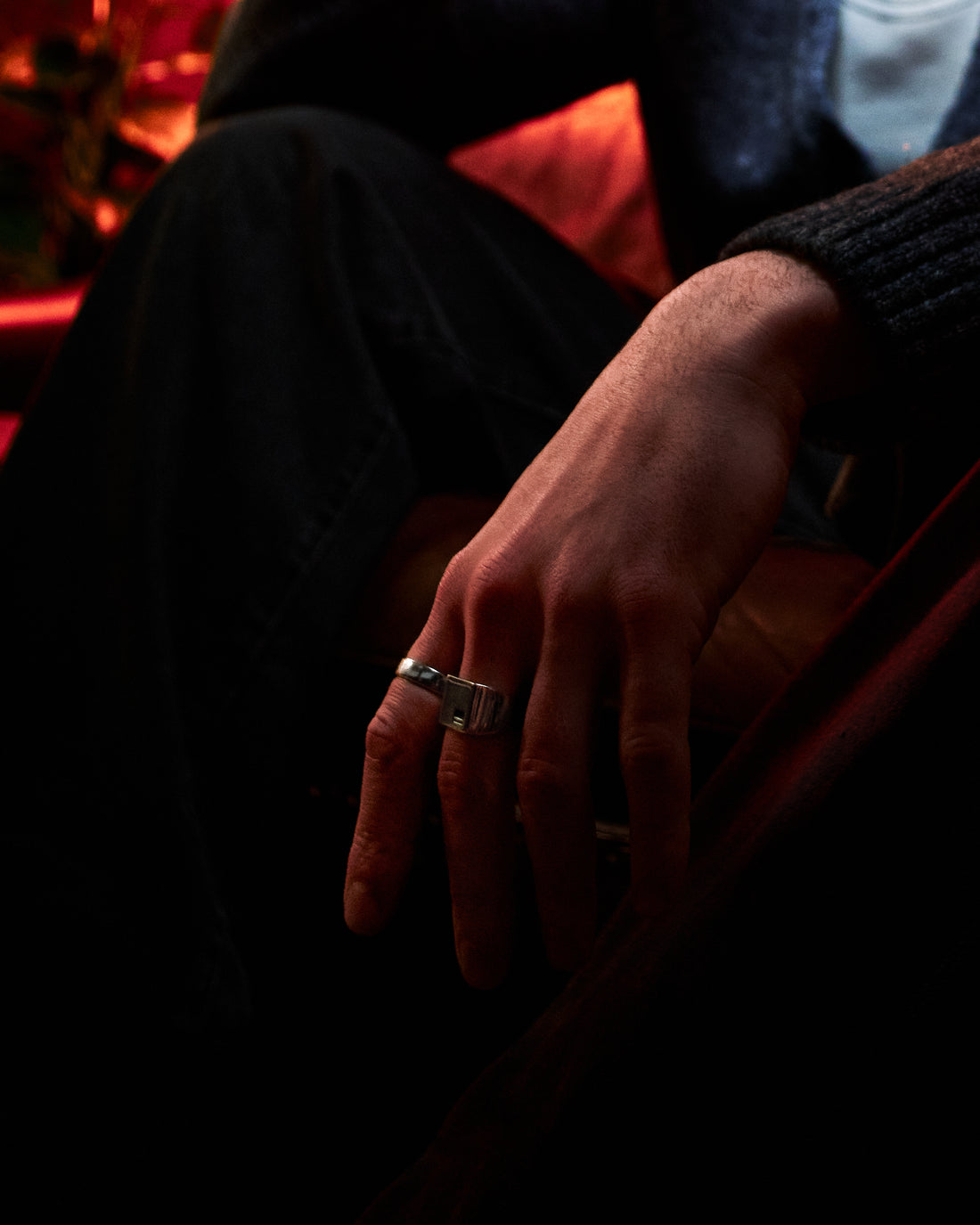 Crown Signet Ring - single ring on hand at rest, low-light editorial setting