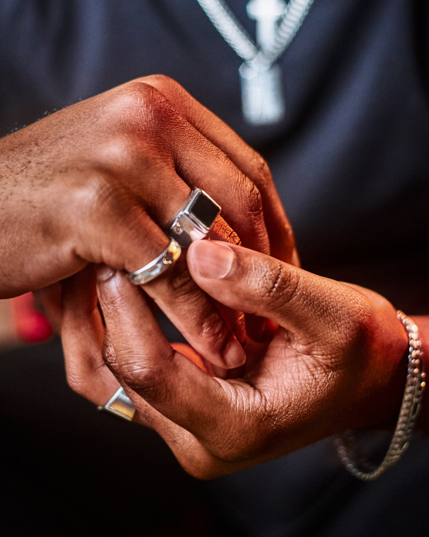 Onyx Signet Ring - styled with Hammered Band Ring, two hands close-up against navy shirt with braided silver chain